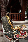 Chiang Mai - Wat Phra That Doi Suthep. The entrance of the vihan dedicated to King Kuena is guarded by Mom, aquatic mythical creatures. 